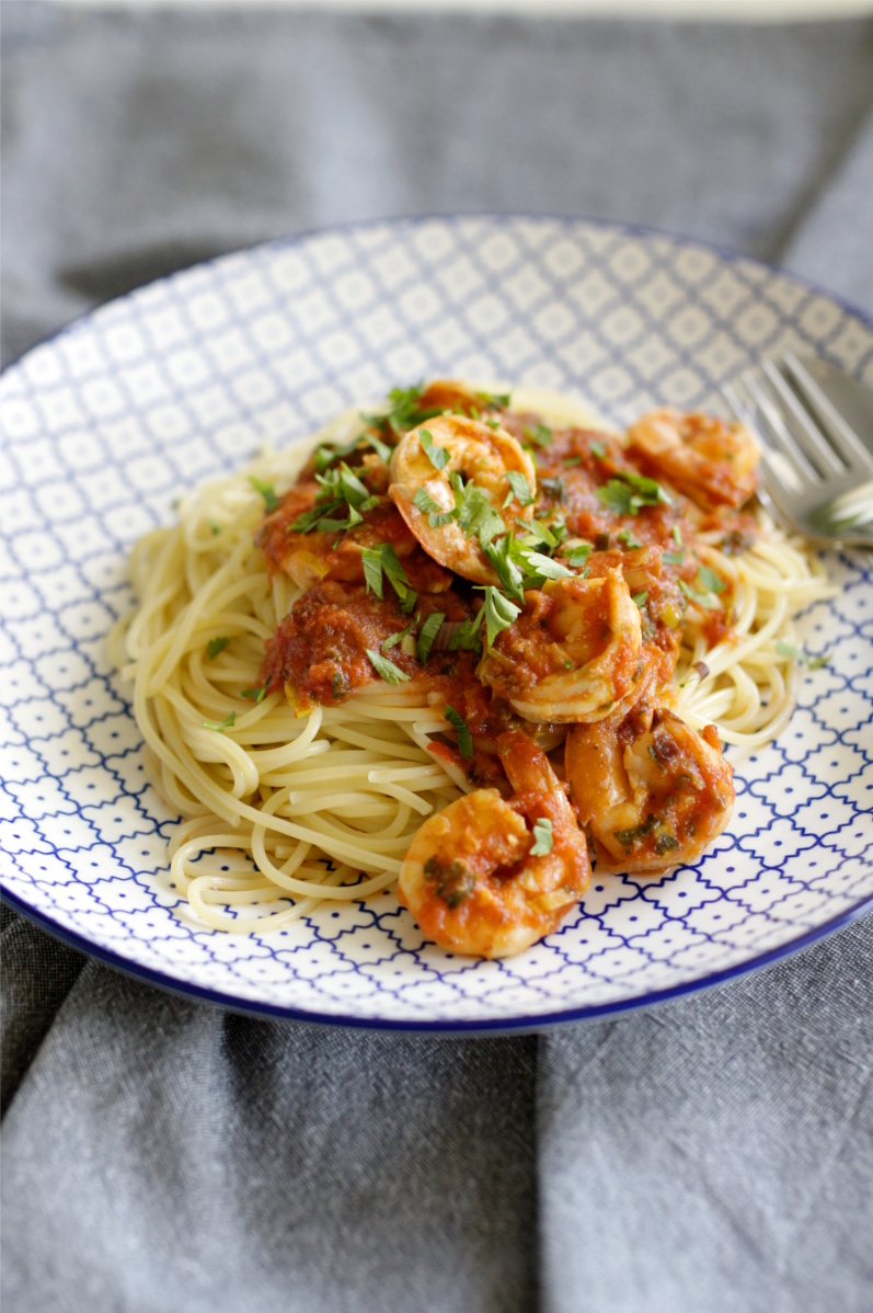 krewetki w sosie pomidorowym z makaronem spaghetti na talerzu