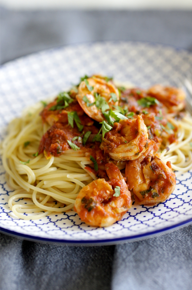 krewetki w sosie pomidorowym z makaronem spaghetti na talerzu