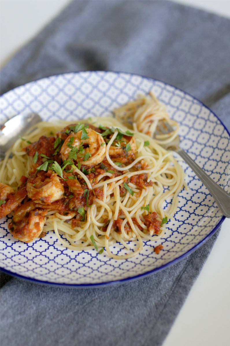 krewetki w sosie pomidorowym z makaronem spaghetti na talerzu