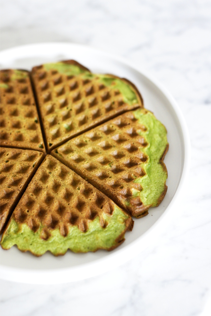 Na białym talerzu leżą upieczone gofry ze szpinakiem i serkiem ricotta.