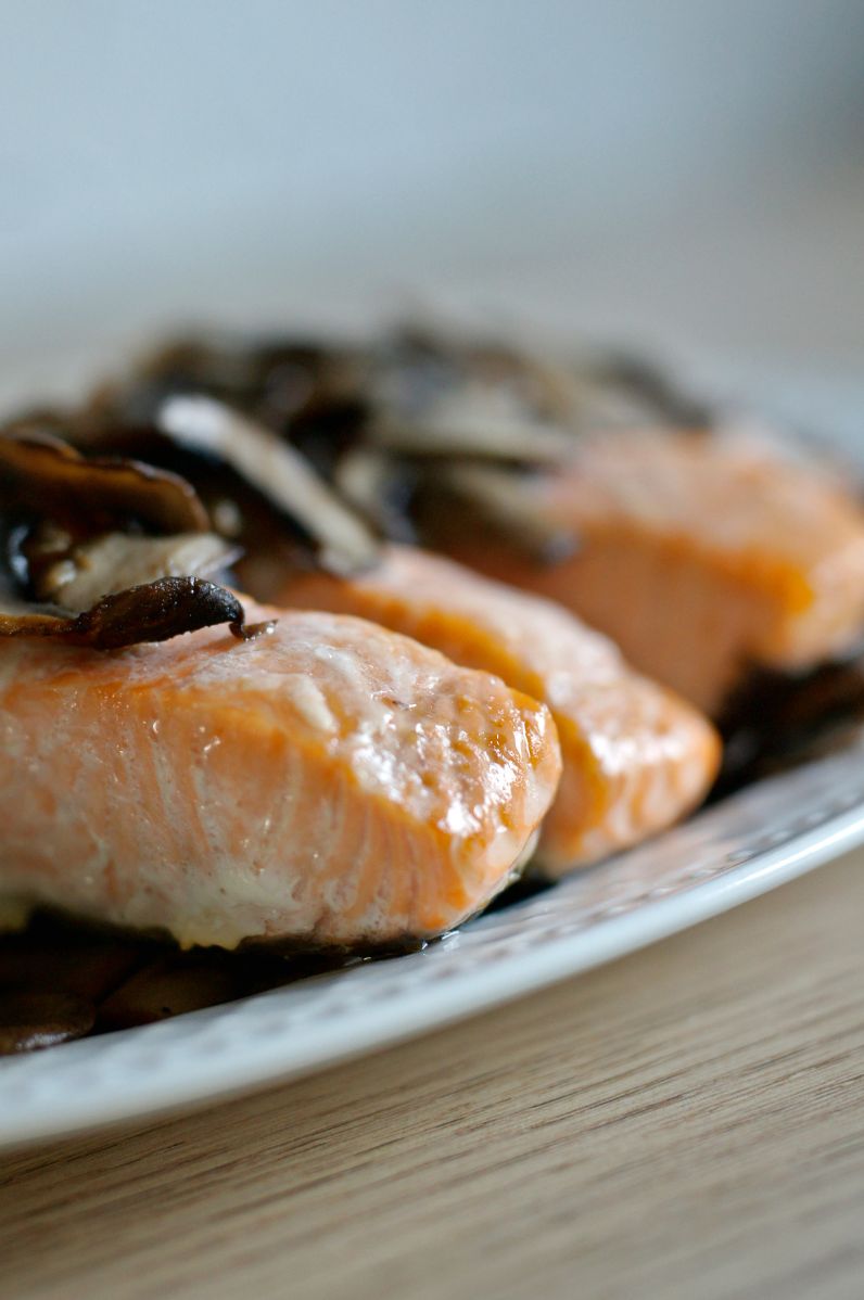 Kawałki pieczonego łososia podane ze smażonymi pieczarkami