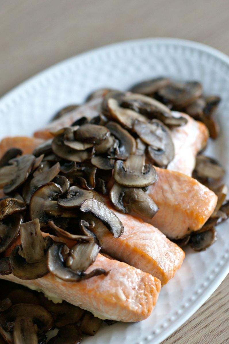 Kawałki pieczonego łososia podane ze smażonymi pieczarkami