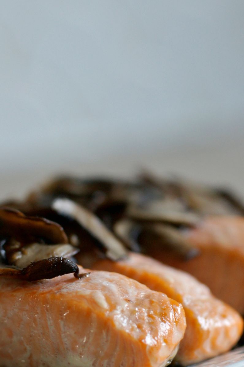 Kawałki pieczonego łososia podane ze smażonymi pieczarkami